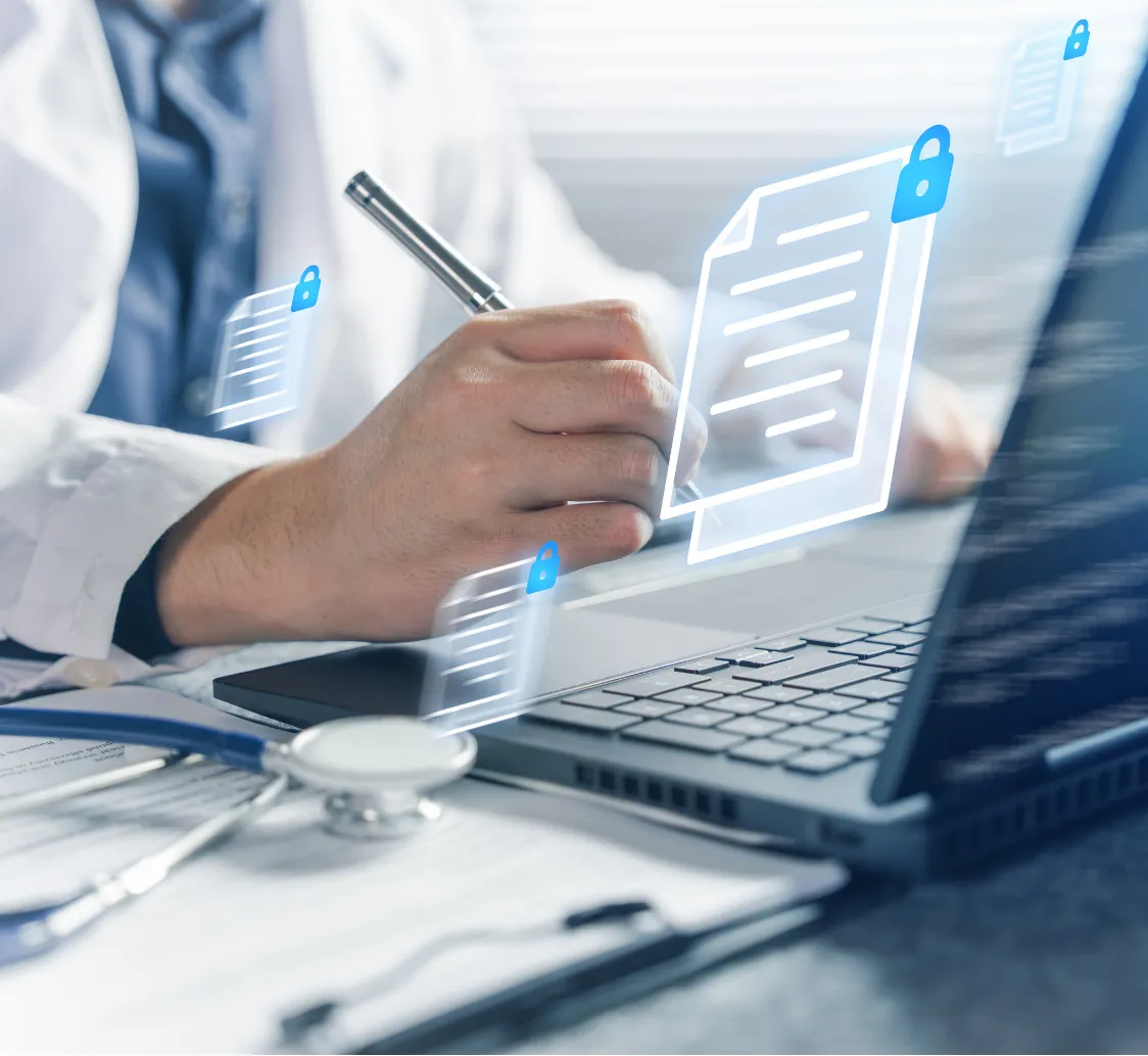 A doctor writing on paper beside a laptop with digital document icons and a stethoscope nearby.
